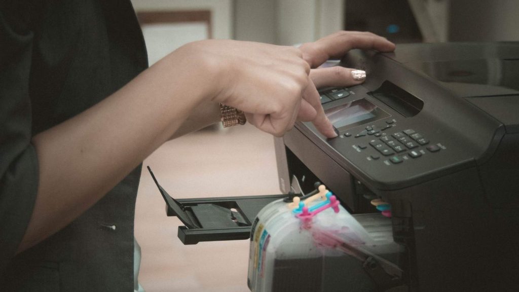 een vrouwenhand bij een printer